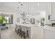 Bright, modern kitchen featuring a large island with seating, stainless steel appliances, and a view to the backyard at 18307 White Fang Ct, Parrish, FL 34219