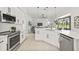 Contemporary kitchen with white cabinetry, stainless steel appliances, and an open layout flowing into the living area at 18307 White Fang Ct, Parrish, FL 34219