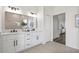 Elegant main bathroom with dual sinks, modern lighting, and an adjacent walk-in closet at 18307 White Fang Ct, Parrish, FL 34219