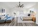 Airy primary bedroom featuring ceiling fan, seating area, and view to kitchen at 18307 White Fang Ct, Parrish, FL 34219