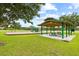 A well-maintained playground with picnic tables and play structures, nestled in a green, Gathering-friendly community space at 18307 White Fang Ct, Parrish, FL 34219