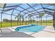 Screened-in pool with integrated spa and sun-drenched deck with views of the lush green lawn at 18307 White Fang Ct, Parrish, FL 34219