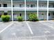 Condo building exterior featuring well-maintained landscaping and clearly marked parking spaces at 1850 Sunny Dr # F4, Bradenton, FL 34207