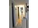 Hallway leading to bathroom with wood floors and a storage cabinet at 1850 Sunny Dr # F4, Bradenton, FL 34207