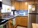 Kitchen with stainless steel refrigerator, wooden cabinets, and granite countertops at 1850 Sunny Dr # F4, Bradenton, FL 34207
