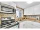 Well-lit kitchen with stainless steel microwave and mosaic tile backsplash at 2014 Canal Dr # M6, Bradenton, FL 34207