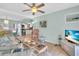 Bright living room with ceiling fan, tile floors, adjacent kitchen, and comfortable seating at 2014 Canal Dr # M6, Bradenton, FL 34207