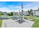Community picnic area with tables, grill, and American flag surrounded by tropical landscaping at 2014 Canal Dr # M6, Bradenton, FL 34207