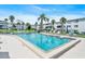 Community swimming pool with lounge chairs surrounded by tropical landscaping and white condo buildings at 2014 Canal Dr # M6, Bradenton, FL 34207