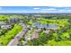 Wide aerial shot showcasing homes within a lush, green community near a golf course and pond at 2417 Fairway Oaks Dr # 22, Palmetto, FL 34221