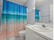 Bright bathroom featuring a white vanity and a shower with a colorful ocean-themed curtain at 2417 Fairway Oaks Dr # 22, Palmetto, FL 34221