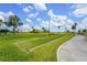 A bocce ball court sits next to a concrete path and a lush green golf course at 2417 Fairway Oaks Dr # 22, Palmetto, FL 34221