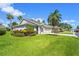 Street view of a single-story home with a lush lawn, palm trees, and a paved driveway at 2417 Fairway Oaks Dr # 22, Palmetto, FL 34221