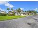 Exterior view of a single-story home with lush lawn, palm trees and a paved driveway at 2417 Fairway Oaks Dr # 22, Palmetto, FL 34221