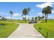 Several golf carts on a paved path surrounded by green grass and palm trees at 2417 Fairway Oaks Dr # 22, Palmetto, FL 34221