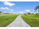 Concrete path leading into open golf course with water feature and blue skies at 2417 Fairway Oaks Dr # 22, Palmetto, FL 34221