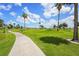 View of a golf course with mature trees and a concrete path at 2417 Fairway Oaks Dr # 22, Palmetto, FL 34221