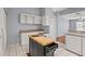 Kitchen featuring white cabinets, an island cooktop, white tile flooring, and modern appliances at 2417 Fairway Oaks Dr # 22, Palmetto, FL 34221
