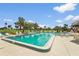 Large outdoor pool surrounded by palm trees, comfortable lounge chairs, and green space at 2417 Fairway Oaks Dr # 22, Palmetto, FL 34221