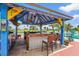 Outdoor tiki bar featuring a grill, seating, and festive decor with a golf course view at 2417 Fairway Oaks Dr # 22, Palmetto, FL 34221