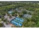 A high-angle shot showcasing the blue and green pickleball courts, pool, and tennis courts at 3003 Quail Holw # 10, Sarasota, FL 34235