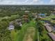 Aerial view of a community with houses bordering a golf course and a pond at 3003 Quail Holw # 10, Sarasota, FL 34235