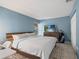 Bright bedroom features a comfortable bed, mounted TV, and golf clubs at 3003 Quail Holw # 10, Sarasota, FL 34235