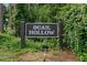 Community sign for Quail Hollow with lush greenery in background at 3003 Quail Holw # 10, Sarasota, FL 34235