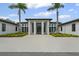 Exterior of the property showcasing the entrance with tall columns and surrounding lush landscaping at 3003 Quail Holw # 10, Sarasota, FL 34235