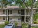 Two-story condo building featuring balconies and landscaping, set in a lush green environment at 3003 Quail Holw # 10, Sarasota, FL 34235
