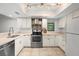 Well-lit kitchen featuring stainless steel appliances, light-colored cabinetry, and tile flooring at 3003 Quail Holw # 10, Sarasota, FL 34235