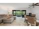 Living room featuring a comfortable sectional sofa, a glass table with wicker chairs, and a sliding glass door to the lanai at 3003 Quail Holw # 10, Sarasota, FL 34235