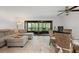 Living room featuring a comfortable sectional sofa, a glass table with wicker chairs, and a sliding glass door to the lanai at 3003 Quail Holw # 10, Sarasota, FL 34235