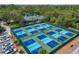Several pickleball courts can be seen, surrounded by lush greenery, offering residents a recreational space at 3003 Quail Holw # 10, Sarasota, FL 34235