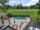 Aerial view of a community pool with lounge chairs, tables, and a clear blue swimming area at 3003 Quail Holw # 10, Sarasota, FL 34235