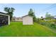 Well-maintained backyard with green grass and a storage shed, partially enclosed by fencing at 326 Randolph Rd, Venice, FL 34293