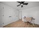 Bright bedroom with wood-look flooring, ceiling fan, work area, and double door closet at 326 Randolph Rd, Venice, FL 34293
