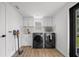Clean laundry room featuring modern washer and dryer, sink and white cabinets at 326 Randolph Rd, Venice, FL 34293