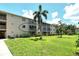 Apartment complex with green lawn and a palm tree at 3985 Maceachen Blvd # 224, Sarasota, FL 34233
