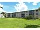 Apartment complex with green lawn and a light blue sky background at 3985 Maceachen Blvd # 224, Sarasota, FL 34233