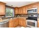 Close-up of the renovated kitchen with stainless steel appliances, granite countertops, and tiled backsplash at 3985 Maceachen Blvd # 224, Sarasota, FL 34233