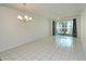Bright living room with tile flooring, chandelier, and a sliding glass door to the balcony at 3985 Maceachen Blvd # 224, Sarasota, FL 34233