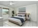 This bedroom features a ceiling fan, and a stylish bed with blue accents and white tile floors at 3985 Maceachen Blvd # 224, Sarasota, FL 34233