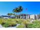 Lush park-like setting with palm trees and an American flag against a clear blue sky at Siesta Beach at 3985 Maceachen Blvd # 224, Sarasota, FL 34233
