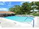 Community swimming pool surrounded by plenty of lounge chairs, with a clubhouse nearby at 3985 Maceachen Blvd # 224, Sarasota, FL 34233