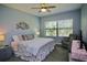 Well-lit bedroom with ceiling fan, large window, and coastal-themed decor exudes relaxation at 4026 Overture Cir # 487, Bradenton, FL 34209