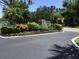 Welcoming entrance to Village Lake, adorned with vibrant foliage and landscaping, invites you into a serene community at 5178 Lake Village Drive # 86, Sarasota, FL 34235