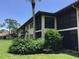 Building exterior showcasing the screened lanai and the lush landscaping at 5178 Lake Village Drive # 86, Sarasota, FL 34235