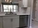 Charming kitchen with bright white cabinetry, stainless dishwasher, and a view of the living space at 5178 Lake Village Drive # 86, Sarasota, FL 34235