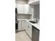 Stylish kitchen boasts stainless appliances, white cabinets, modern countertops, and neutral tile flooring at 5178 Lake Village Drive # 86, Sarasota, FL 34235